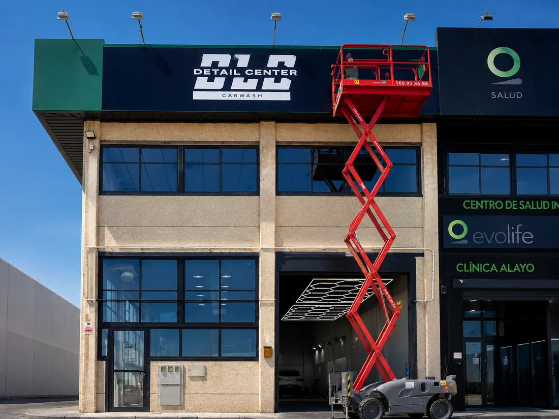 Instalación del rótulo de fachada de DLC Detail Center con una plataforma elevadora de tijera.